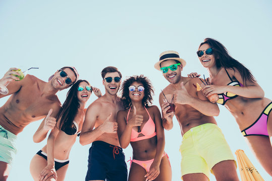 Low angle photo of charming bachelors enjoying holding glass juice laughing wearing eyeglasses eyewear standing outdoors