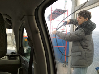 Man washing his car in a self-service car wash station. winter. Shooting from inside the car
