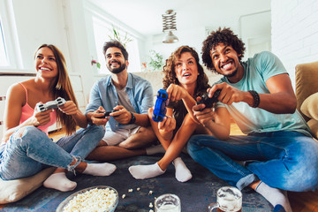 Group of friends play video games together at home, having fun.