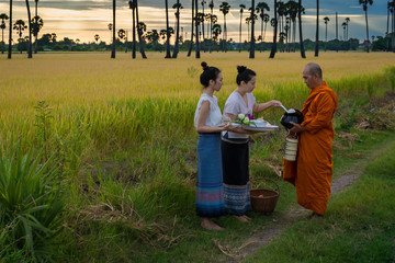 Women make merit with monk in rural areas according to the beliefs of Buddhism in Thailand