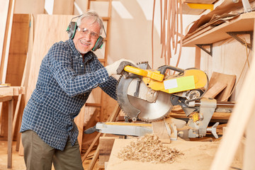 Craftsman with ear protection at the chop saw