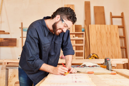 Young craftsman draws a blueprint