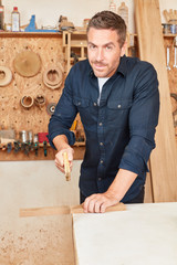 Carpenter with a fox tail hand saw