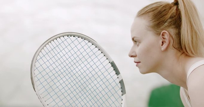 CU Portrait of focused young Caucasian female tennis player preparing for a serve. 120 FPS slow motion, 4K UHD RAW graded footage