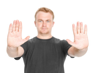 Fototapeta premium Man in black t-shirt with blurred face with a gesture of stop isolated white background