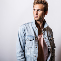 Handsome young man in jeans jacket pose in studio.