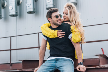 beautiful and blonde woman hugging handsome man in glasses