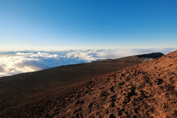 rocky volcanic landscape above the clouds