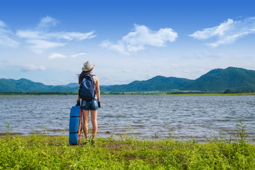 Fototapeta na wymiar woman traveler standing near the lake background is the mountain and enjoying for beautiful view of nature on holiday.adventure concept.