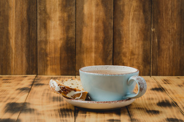 Tea cup and pastries piece on wooden table. Breakfast. Selective focus