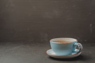 Blue cup of tea on dark stone background, selective focus and copyspace for text