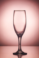 Empty champagne wine glass on pink background 
