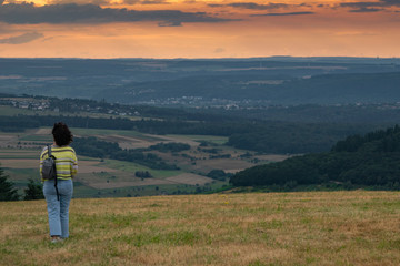 Eine Frau blickt am Abend in ein Tal, A woman looks into a valley in the evening