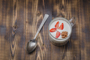 yogurt in glass with a granule and nuts decorated with strawberry. Top view, copyspace