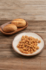 a plate of chickpea and bread on a wooden table