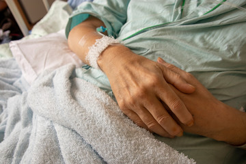 病院のベッドで点滴を受ける男性