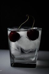 стакан со льдом, лимоном и черешней