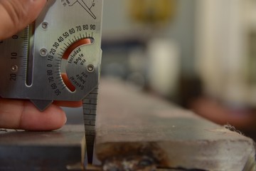 Technician's hand catch the welding gauge to measuring the gap between work part before the welding