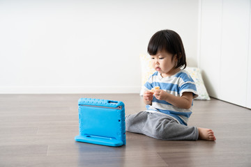 タブレットパソコンで動画を見る子供