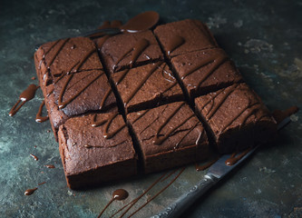 Brownie cake dessert. Dark sponge cake with cocoa and chocolate on a old textural table.