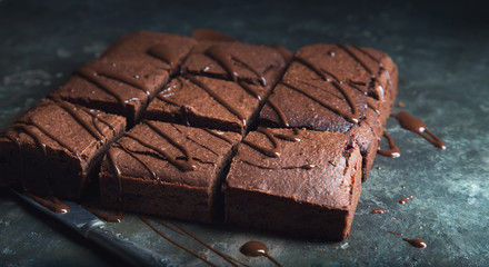 Brownie cake dessert. Dark sponge cake with cocoa and chocolate on a old textural table.
