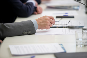 Group of businesspeople or lawyers discussing contract papers and financial figures while sitting at the table. Close-up of human hands  Success and communication concept