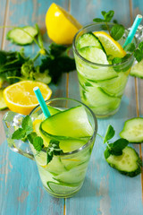 Glasses with fresh organic Cold and refreshing infused detox water with lemon and cucumber on...