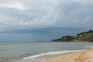 Seashore at sunset time before the thunderstorm rain the distance on the horizon, beautiful white clouds turning into dark blue rain