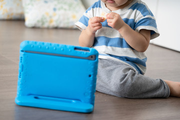 タブレットパソコンで動画を見る子供