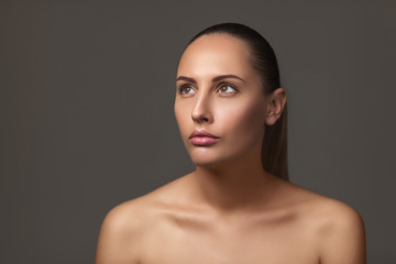 Beauty portrait of female face with natural perfect skin. model with light nude make-up on dark background. copy space