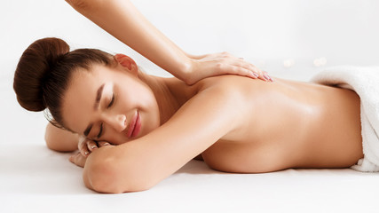 Fototapeta premium Beautiful woman receiving back massage in beauty parlor