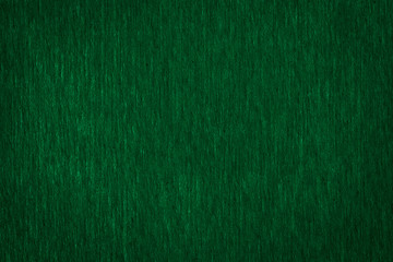 Abstract texture of a rough dark green paper background and copy space for text. Macro fiber paper.