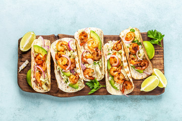 Shrimp tacos. Seafood fajitas with cabbage, onion, parsley in tortillas served on wooden cutting...