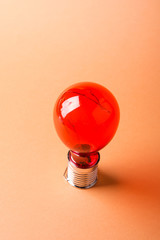 Red solar light bulb on orange