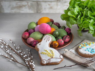 Easter gingerbread Bunny and colorful eggs on a light background, a bunch of lettuce