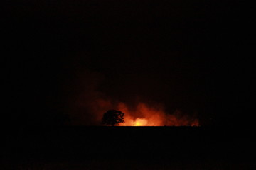 isolated bush fire blazing in the distance on a farm at night time in rural Victoria, Australia