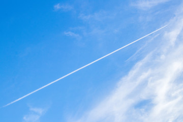 The contrails or the condensation trails in the blue sky background