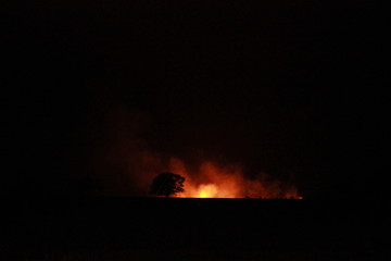 isolated bush fire blazing in the distance on a farm at night time in rural Victoria, Australia