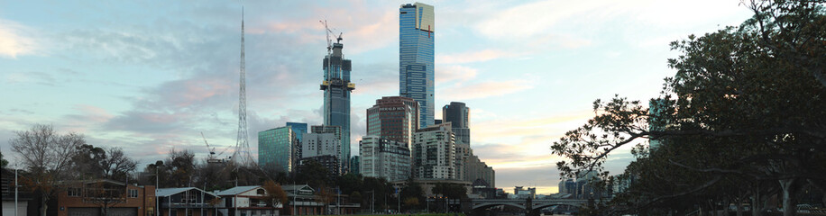 Fototapeta premium panoramic sunset view of Melbourne city central CBD skyscraper buildings by the Yarra river, Central Victoria, Australia