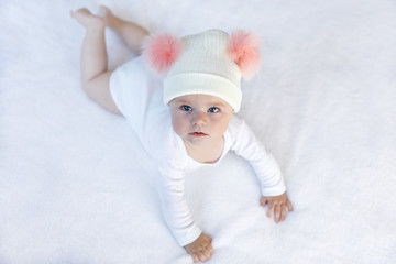 Cute adorable baby child with warm white and pink hat with cute bobbles