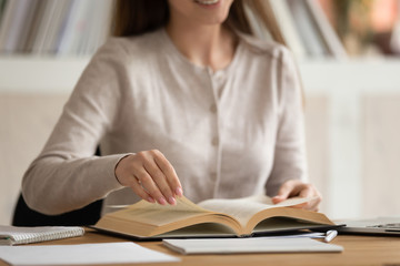 Close up of girl student reading book studying at home