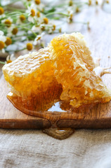Two sweet honeycomb slices on a wooden cutting board 