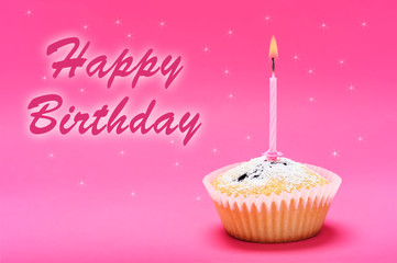 Celebration greetings- single muffin cake with burning candle on a pink background with happy birthday text