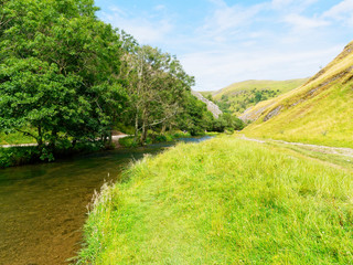 Peaceful summer afternoon by the River Dove in Dovedale in the Derbyshire Peak District