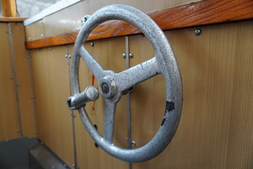 old tram, with brown wooden interior trim and steering wheel at the end of the car. large Windows, comfortable interior