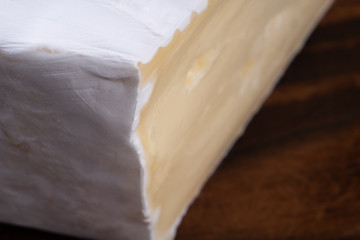 Sliced smelly camembert cheese on a wooden rustic table