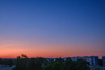 Obraz premium red sunset over city with housing and internet provider cables in the sky