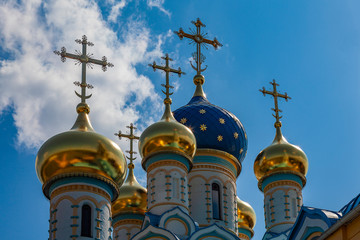 Fototapeta na wymiar Blue and golden domes of an orthodox temple against a cloudy sky
