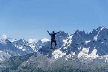 A man walking along a sling against the backdrop of the Alps. Chamonix France.