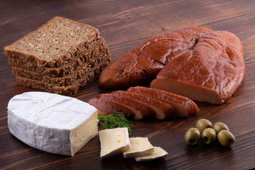 raw smoked cod caviar with camembert cheese, olives, bread on wooden background